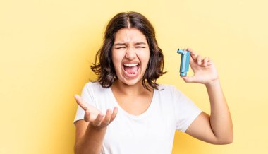 Genç İspanyol kadın kızgın, sinirli ve hayal kırıklığına uğramış görünüyor. astım konsepti