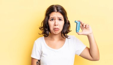 Genç İspanyol kadın üzgün ve mızmızlanıyor. Mutsuz bir bakışı var ve ağlıyor. astım konsepti