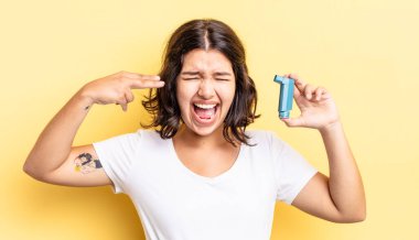 Genç İspanyol kadın mutsuz ve stresli görünüyor, intihar jesti silah işareti yapıyor. astım konsepti