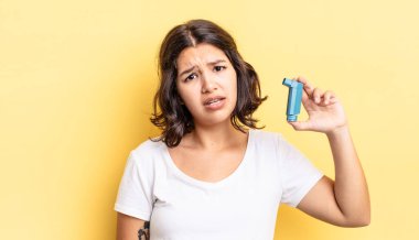 Genç İspanyol kadın şaşkın ve şaşkın hissediyor. astım konsepti