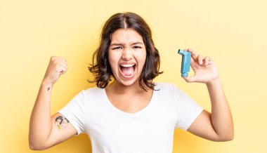 Genç İspanyol kadın öfkeli bir ifadeyle agresif bir şekilde bağırıyor. astım konsepti