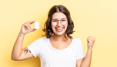 Genç İspanyol kadın şokta, gülüyor ve başarıyı kutluyor. hastalık hapları konsepti