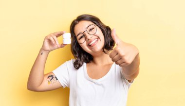 Genç İspanyol kadın gururlu, olumlu bir şekilde gülümsüyor. hastalık hapları konsepti