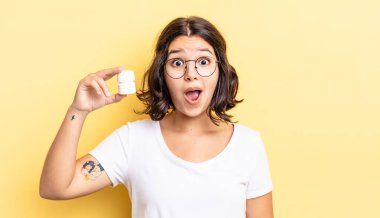 Genç İspanyol kadın çok şaşırmış ya da şok olmuş görünüyor. hastalık hapları konsepti