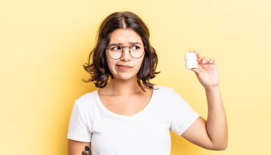 Genç İspanyol kadın üzgün, üzgün ya da kızgın hissediyor ve yana bakıyor. hastalık hapları konsepti