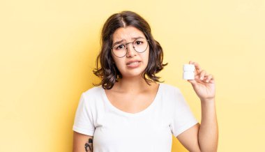 Genç İspanyol kadın şaşkın ve şaşkın hissediyor. hastalık hapları konsepti