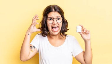 Genç İspanyol kadın ellerini havaya kaldırarak çığlık atıyor. hastalık hapları konsepti