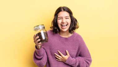 Genç İspanyol kadın komik bir şakaya yüksek sesle gülüyor. kahve çekirdeği konsepti