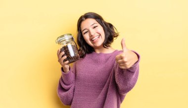 Genç İspanyol kadın gururlu, olumlu bir şekilde gülümsüyor. kahve çekirdeği konsepti