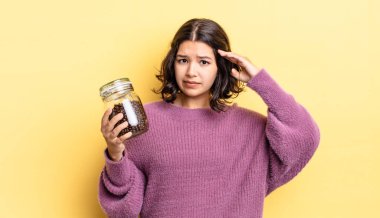 Genç İspanyol kadın şaşkın ve şaşkın hissediyor, senin deli olduğunu gösteriyor. kahve çekirdeği konsepti