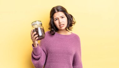 Genç İspanyol kadın şaşkın ve şaşkın hissediyor. kahve çekirdeği konsepti