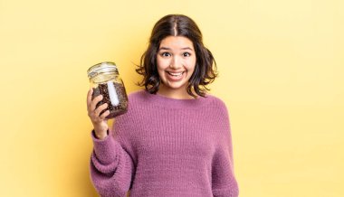 Genç İspanyol kadın mutlu ve hoş bir şekilde şaşırmış görünüyor. kahve çekirdeği konsepti