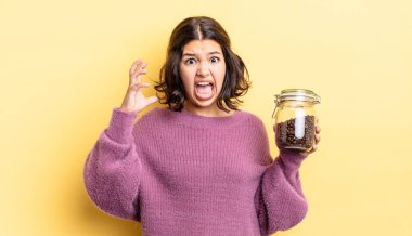 Genç İspanyol kadın ellerini havaya kaldırarak çığlık atıyor. kahve çekirdeği konsepti