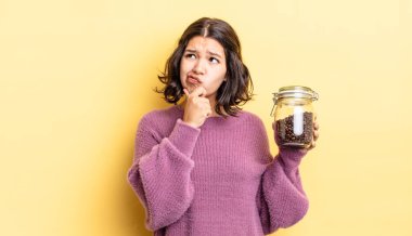 Genç İspanyol kadın düşünüyor, kuşkulu ve şaşkın hissediyor. kahve çekirdeği konsepti