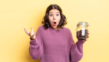 Genç İspanyol kadın şok olmuş ve şaşırmış hissediyor. kahve çekirdeği konsepti