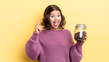 Genç İspanyol kadın bir fikri fark ettikten sonra mutlu ve heyecanlı bir dahi gibi hissediyor. kahve çekirdeği konsepti