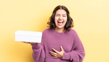 Genç İspanyol kadın komik bir şakaya yüksek sesle gülüyor. boş kutu kavramı