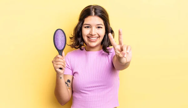 Jonge Spaanse Vrouw Glimlachend Vriendelijk Toont Nummer Twee Haarborstel Concept — Stockfoto