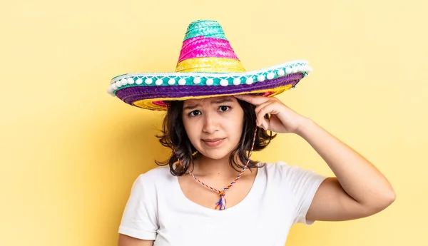 若いヒスパニック系の女性は混乱して困惑しているあなたが狂っていることを示しています メキシコの帽子のコンセプト — ストック写真