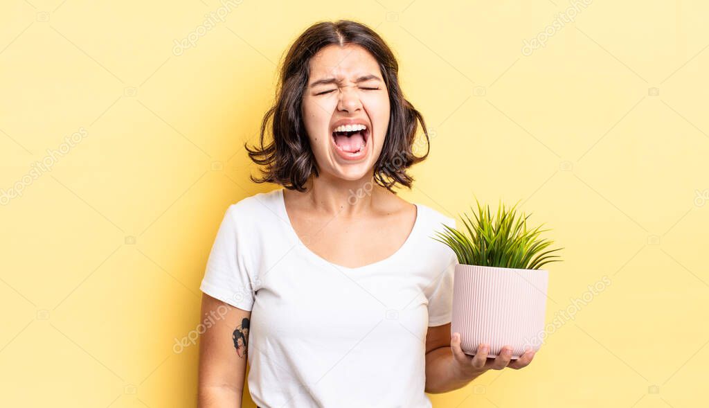 young hispanic woman shouting aggressively, looking very angry. growth concept