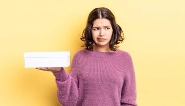 Genç İspanyol kadın üzgün, üzgün ya da kızgın hissediyor ve yana bakıyor. boş kutu kavramı