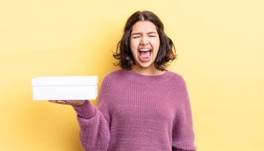 Genç İspanyol kadın agresif bir şekilde bağırıyor, çok kızgın görünüyor. boş kutu kavramı