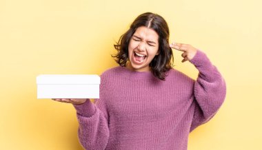 Genç İspanyol kadın mutsuz ve stresli görünüyor, intihar jesti silah işareti yapıyor. boş kutu kavramı