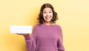 Genç İspanyol kadın mutlu ve hoş bir şekilde şaşırmış görünüyor. boş kutu kavramı