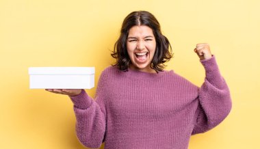 Genç İspanyol kadın öfkeli bir ifadeyle agresif bir şekilde bağırıyor. boş kutu kavramı