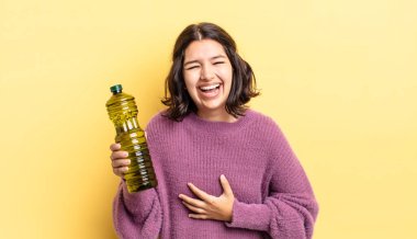 Genç İspanyol kadın komik bir şakaya yüksek sesle gülüyor. Zeytin yağı kavramı