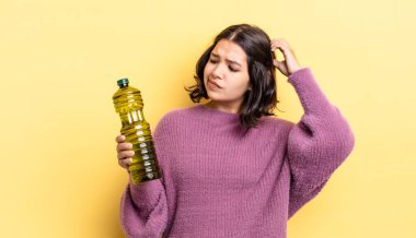 Genç İspanyol kadın şaşkın ve kafası karışık, kaşınan bir kafa hissediyor. Zeytin yağı kavramı