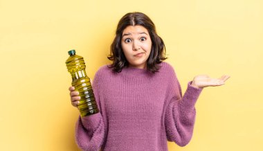 Genç İspanyol kadın şaşkın, şaşkın ve şüpheci hissediyor. Zeytin yağı kavramı