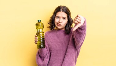 Latin kökenli genç bir kadın kızmış, baş parmağını kaldırmış. Zeytin yağı kavramı