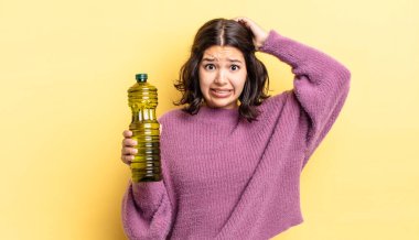 Genç İspanyol kadın stresli, endişeli ya da korkmuş hissediyor, elleri başının üstünde. Zeytin yağı kavramı