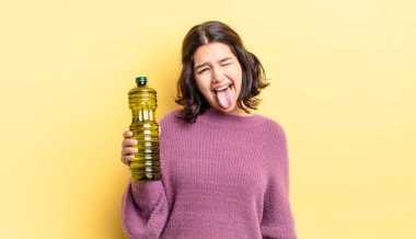 Neşeli ve asi tavırları olan, şaka yapan ve dilini dışarı çıkaran genç İspanyol bir kadın. Zeytin yağı kavramı