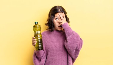 Genç İspanyol bir kadın şok olmuş, korkmuş ya da korkmuş görünüyor. Yüzü elle kapatılmış. Zeytin yağı kavramı