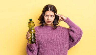 Genç İspanyol kadın şaşkın ve şaşkın hissediyor, senin deli olduğunu gösteriyor. Zeytin yağı kavramı
