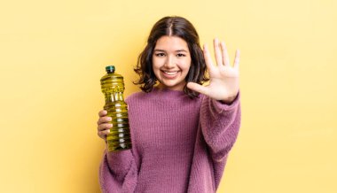 Genç İspanyol kadın gülümsüyor ve arkadaş canlısı görünüyor, beş numarayı gösteriyor. Zeytin yağı kavramı