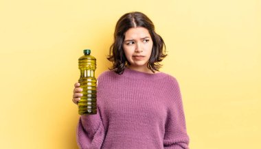 Genç İspanyol kadın üzgün, üzgün ya da kızgın hissediyor ve yana bakıyor. Zeytin yağı kavramı