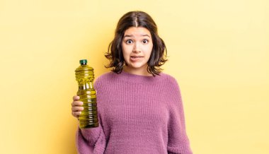 Genç İspanyol kadın şaşkın ve şaşkın görünüyor. Zeytin yağı kavramı