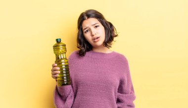 Genç İspanyol kadın şaşkın ve şaşkın hissediyor. Zeytin yağı kavramı