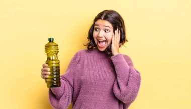 Genç İspanyol kadın mutlu, heyecanlı ve şaşırmış hissediyor. Zeytin yağı kavramı