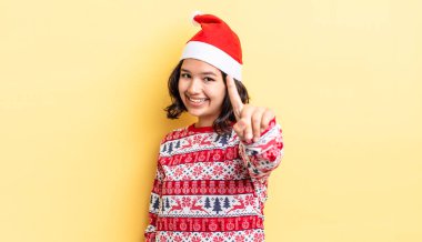 Genç İspanyol kadın gururla gülümsüyor ve kendinden emin bir numara oluyor. Noel konsepti