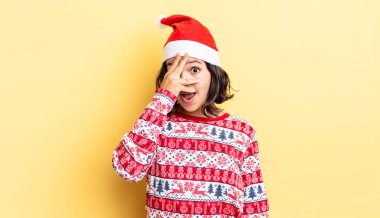 Genç İspanyol bir kadın şok olmuş, korkmuş ya da korkmuş görünüyor. Yüzü elle kapatılmış. Noel konsepti