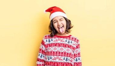 Neşeli ve asi tavırları olan, şaka yapan ve dilini dışarı çıkaran genç İspanyol bir kadın. Noel konsepti