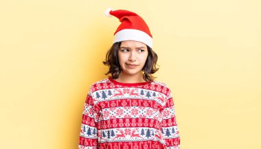 Genç İspanyol kadın üzgün, üzgün ya da kızgın hissediyor ve yana bakıyor. Noel konsepti