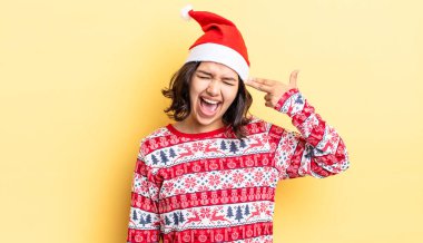 Genç İspanyol kadın mutsuz ve stresli görünüyor, intihar jesti silah işareti yapıyor. Noel konsepti