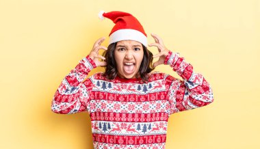 Genç İspanyol kadın ellerini havaya kaldırarak çığlık atıyor. Noel konsepti