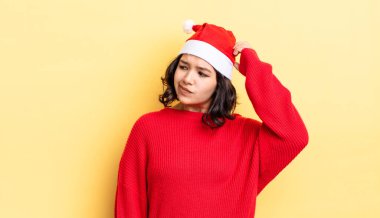 Genç İspanyol kadın mutlu bir şekilde gülümsüyor ve hayal kuruyor ya da şüphe ediyor. Noel konsepti