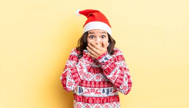 Genç İspanyol kadın şok olmuş ellerle ağzını kapatıyor. Noel konsepti